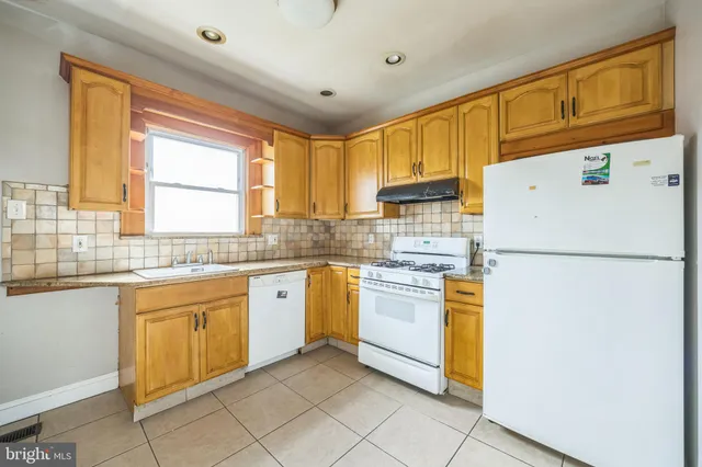 a kitchen with granite countertop appliances a sink and a refrigerator