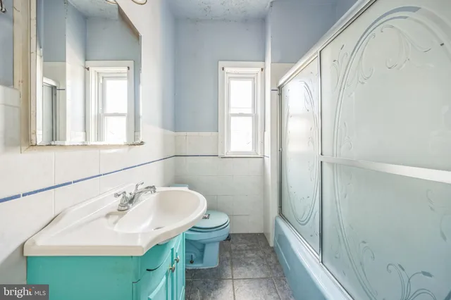 a bathroom with a sink a toilet and a mirror