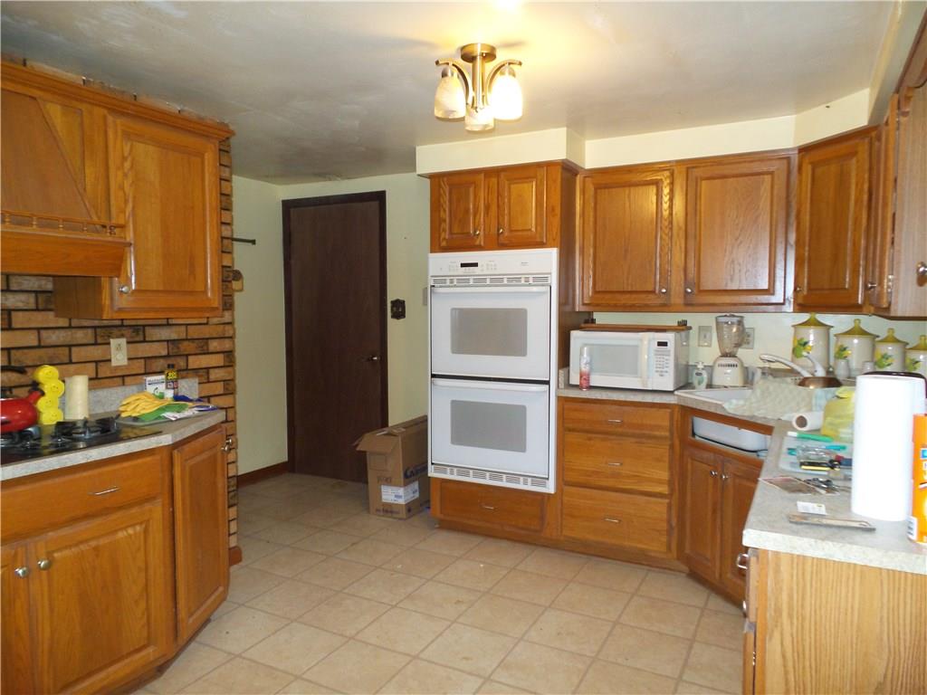 2230 Hyland Road Harrison City, PA 15636 - Photo 7 of 25 Updated kitchen with double ovens and plenty of space to work. Door leads into laundry/work room that could be converted back to a double garage.