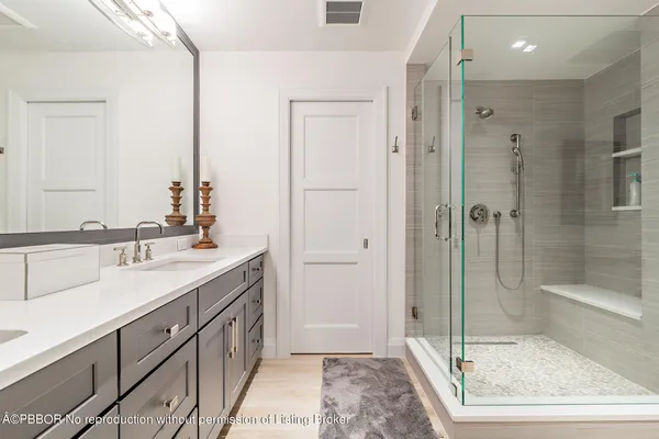 a bathroom with a shower sink and mirror