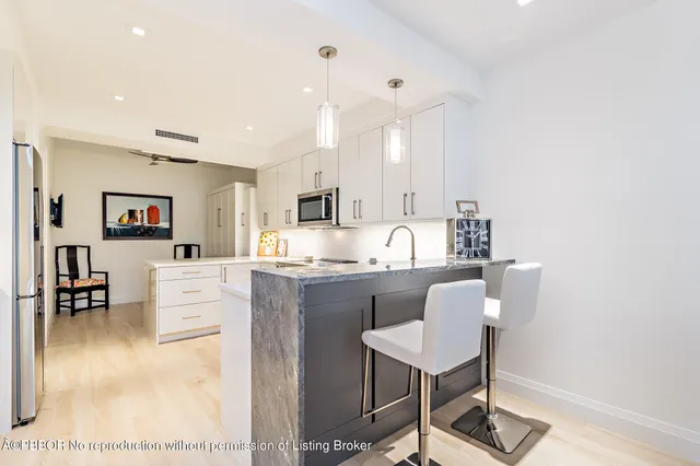 a kitchen with stainless steel appliances kitchen island granite countertop a stove a sink a dining table and chairs