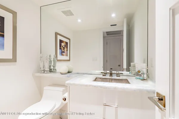 a bathroom with a sink a toilet and mirror