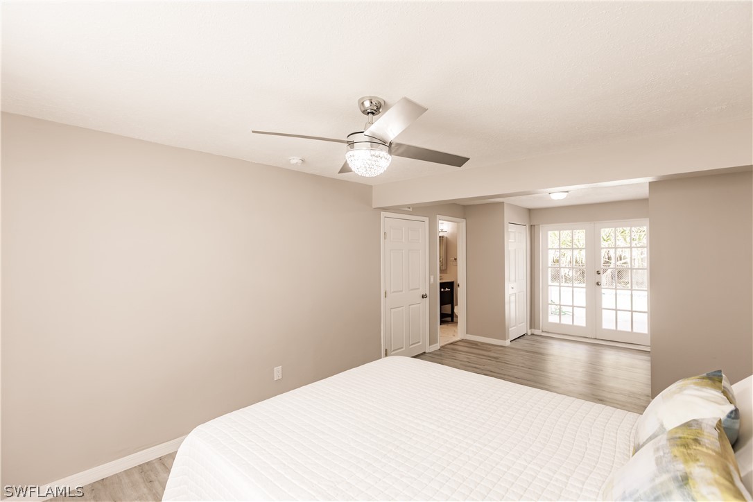 8049 Albatross Road Fort Myers, FL 33967 - Photo 13 of 35 a bedroom with a bed and a chandelier