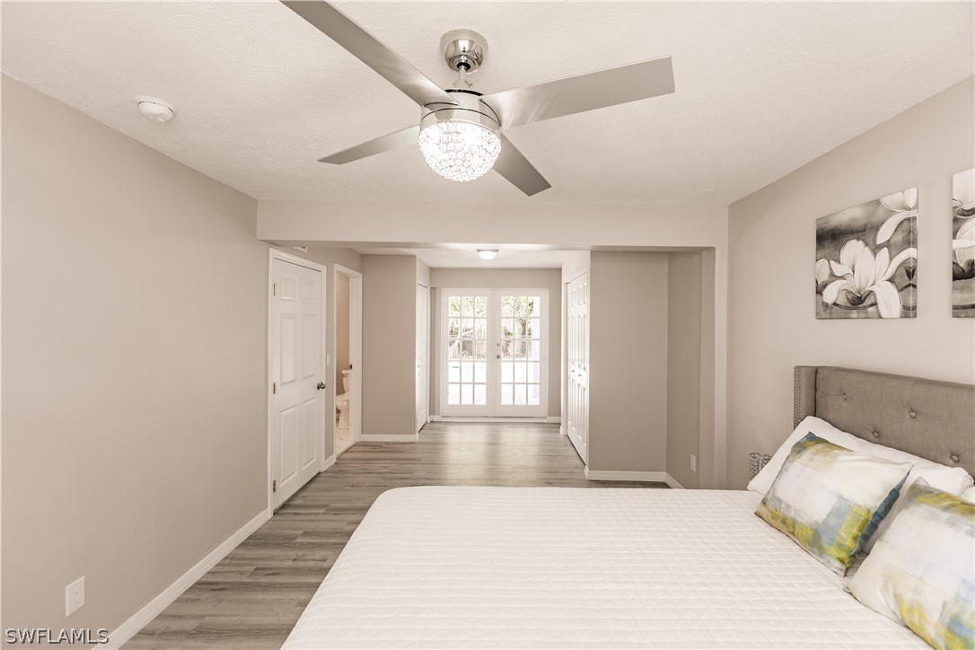 8049 Albatross Road Fort Myers, FL 33967 - Photo 14 of 35 a bedroom with a large bed and a chandelier