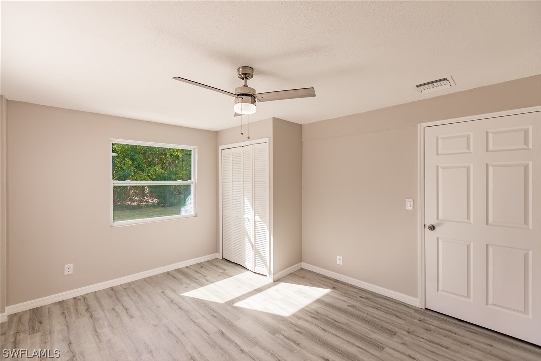 8049 Albatross Road Fort Myers, FL 33967 - Photo 17 of 35 a view of an empty room with wooden floor and a window