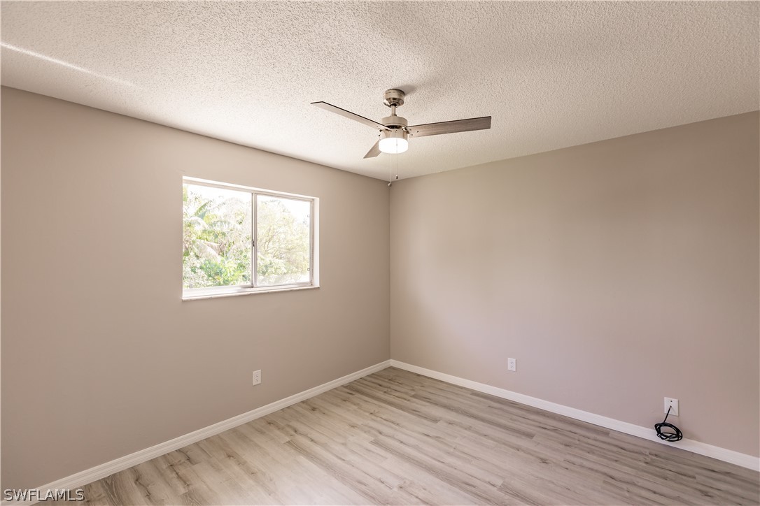 8049 Albatross Road Fort Myers, FL 33967 - Photo 25 of 35 wooden floor in an empty room with a window