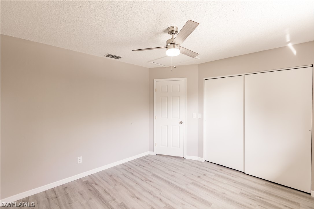 8049 Albatross Road Fort Myers, FL 33967 - Photo 26 of 35 an empty room with wooden floor fan and windows