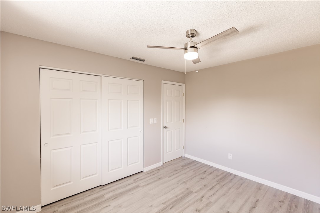 8049 Albatross Road Fort Myers, FL 33967 - Photo 29 of 35 an empty room with wooden floor fan and windows
