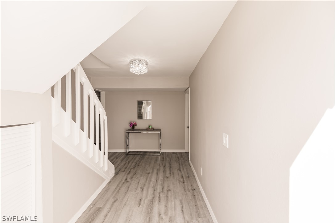 8049 Albatross Road Fort Myers, FL 33967 - Photo 4 of 35 a view of a hallway with wooden floor and staircase