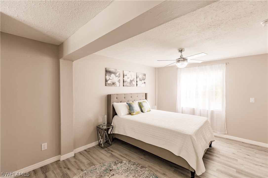 8049 Albatross Road Fort Myers, FL 33967 - Photo 9 of 35 a bedroom with a bed and a chandelier