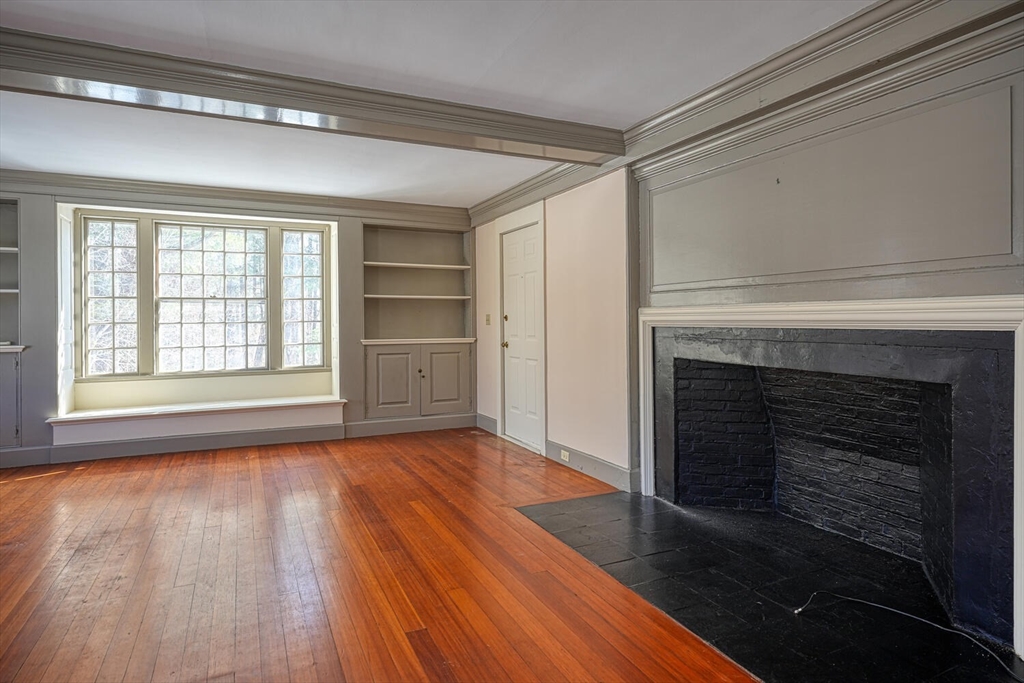 a view of an empty room with a fireplace and a window