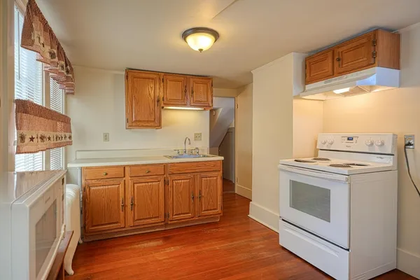 a kitchen with granite countertop white cabinets and white appliances