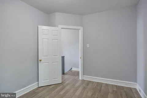 a view of an empty room with closet and a window