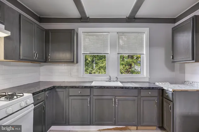 a kitchen with granite countertop cabinets stainless steel appliances a sink and a window