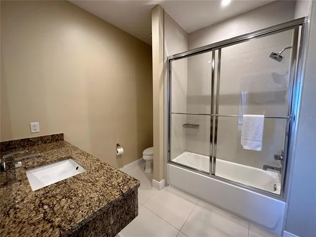 a bedroom with a bed and a glass door shower