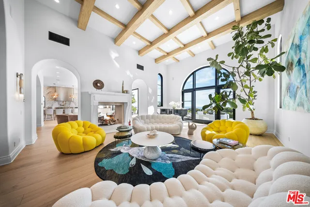 a living room with fireplace furniture and a large window