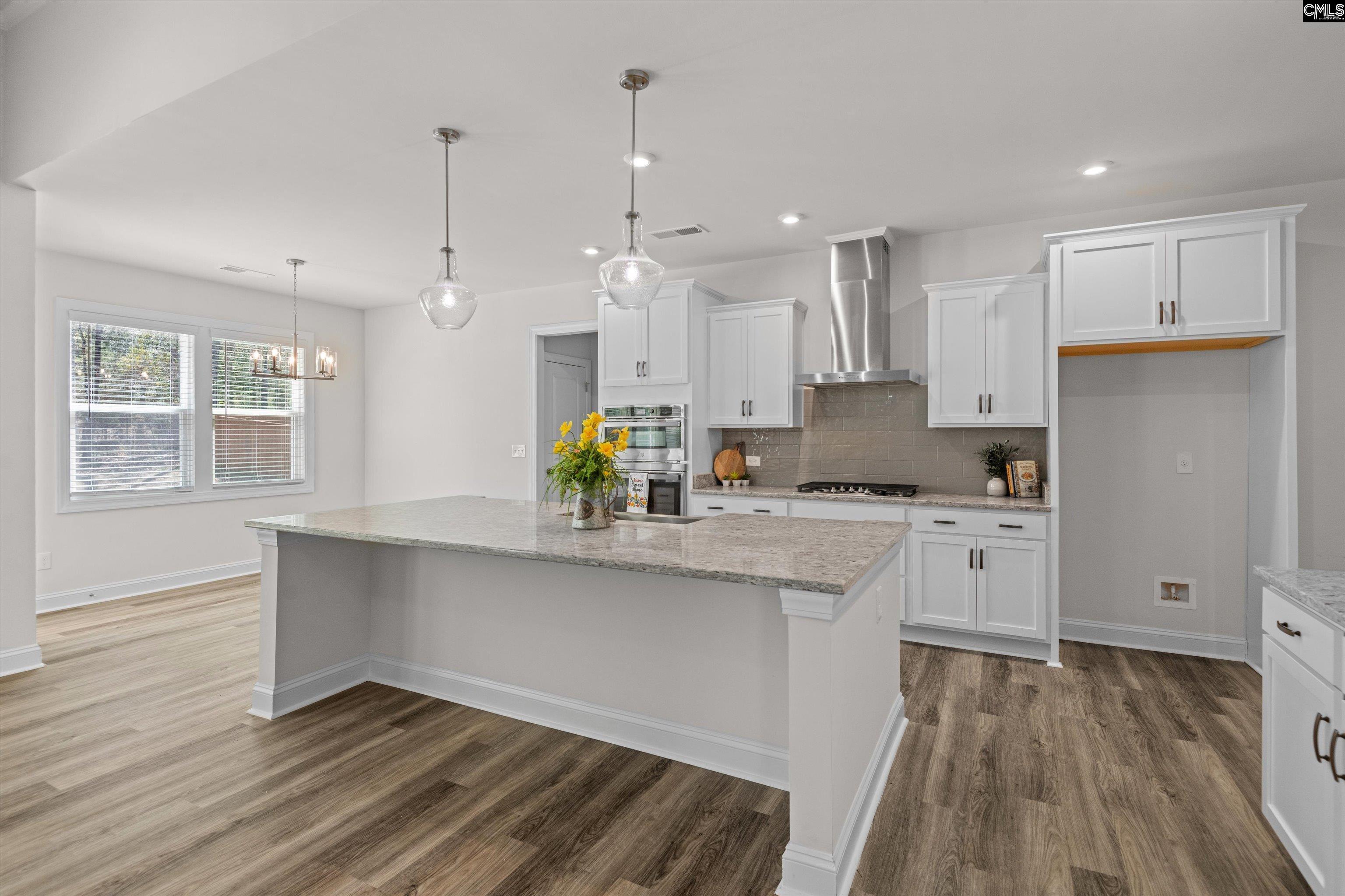 558 Wild Ginger Loop Irmo, SC 29063 - Photo 13 of 42 a kitchen with stainless steel appliances granite countertop a refrigerator a sink dishwasher a stove and white cabinets with wooden floor