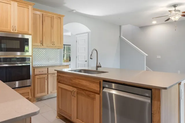 an empty room with windows and ceiling fan