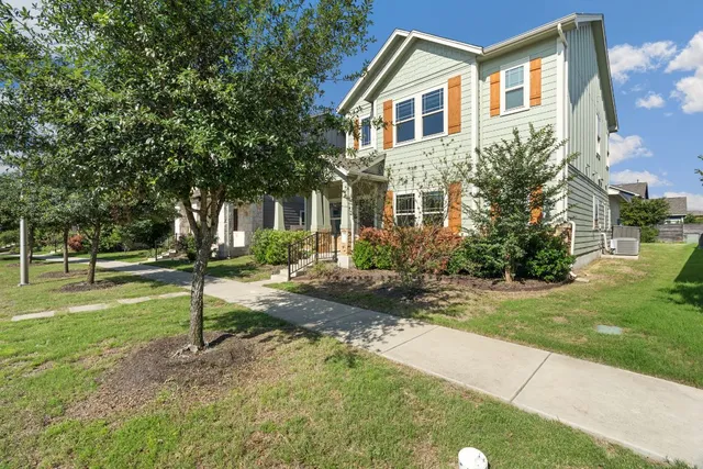 a front view of a house with a yard and trees