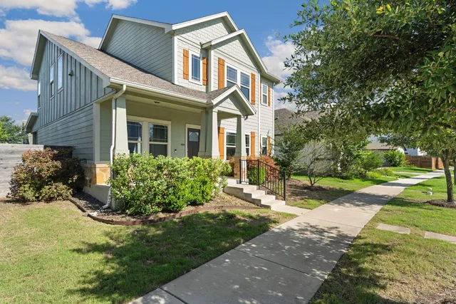 a front view of a house with a yard and trees