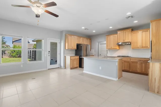 a kitchen with stainless steel appliances granite countertop a refrigerator a stove top oven a sink and dishwasher