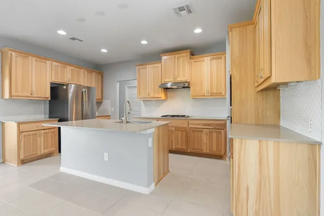 a kitchen with a sink a stove and cabinets