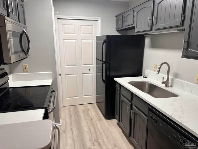 a kitchen with stainless steel appliances a refrigerator a sink a stove and cabinets
