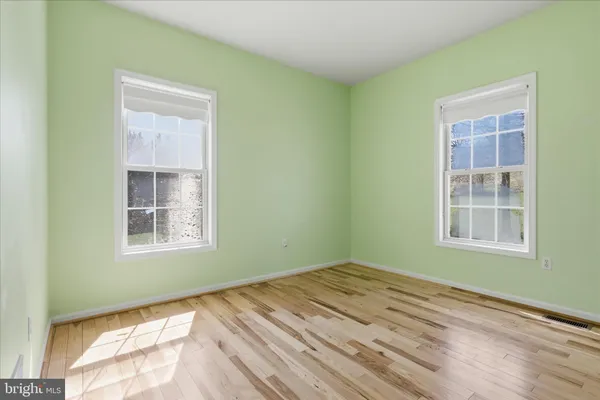 en empty room with windows and ceiling fan