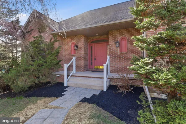 a view of an empty room with wooden floor and a kitchen