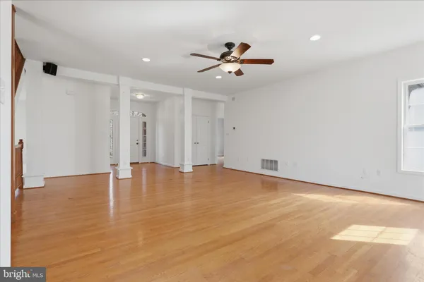 a view of empty room with wooden floor and fireplace