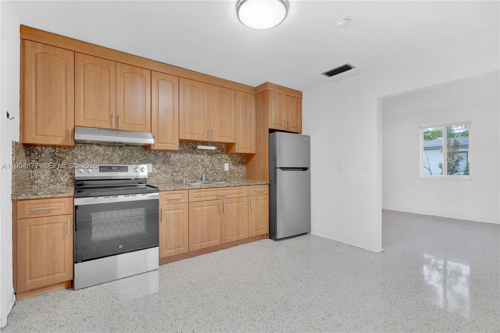 2931 Southwest 39th Avenue Miami, FL 33134 - Photo 7 of 27 a kitchen with a refrigerator sink stove and cabinets