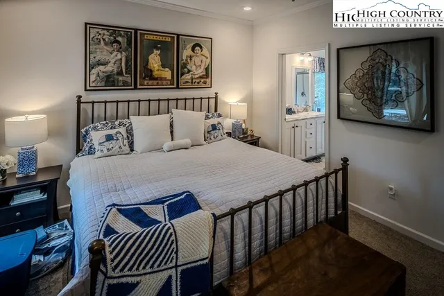 a bedroom with a bed a painting on the wall and a dresser