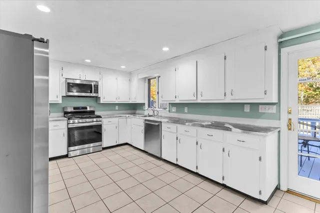 a view of an empty room with a fireplace and a window