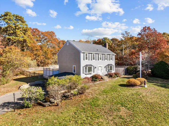 a front view of a house with a yard and trees