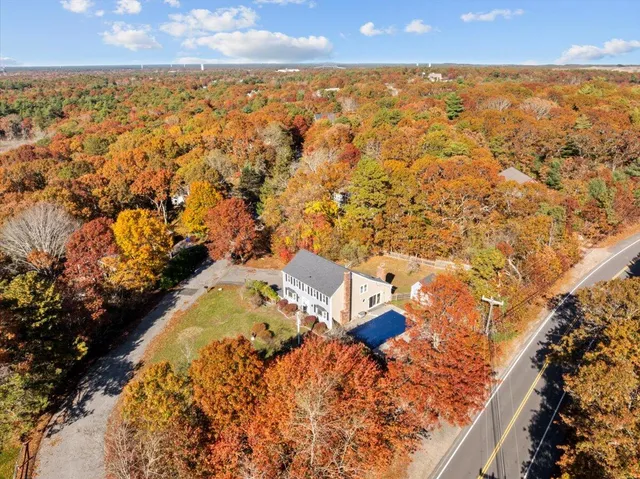 a view of a hallway with wooden floor and a bathroom
