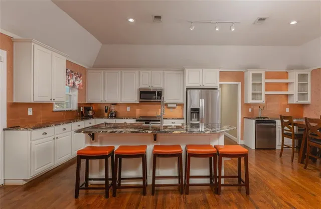 a kitchen with a table chairs microwave and cabinets