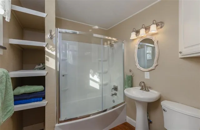 a bathroom with a sink toilet and a mirror