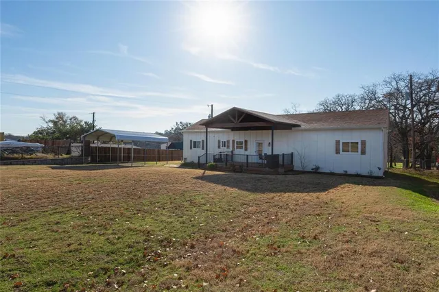 a front view of a house with a yard and trees