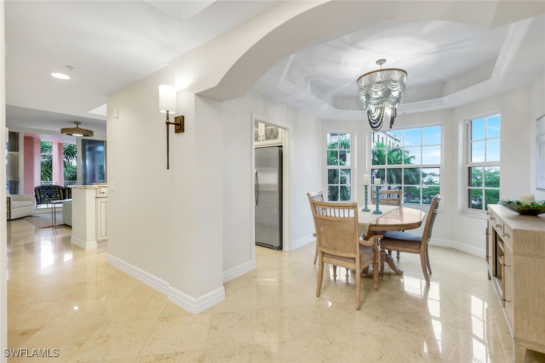 401 Bayfront Place, Unit 3301 Naples, FL 34102 - Photo 13 of 30 a view of a dining room with furniture wooden floor and chandelier