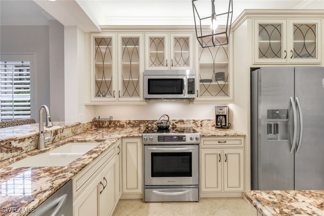 401 Bayfront Place, Unit 3301 Naples, FL 34102 - Photo 7 of 30 a kitchen with stainless steel appliances granite countertop a stove a sink and a microwave