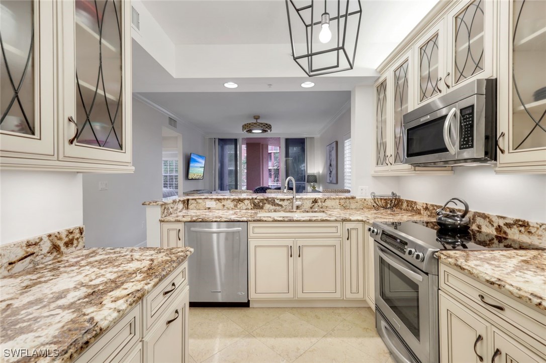 401 Bayfront Place, Unit 3301 Naples, FL 34102 - Photo 9 of 30 a kitchen with stainless steel appliances granite countertop a stove and a sink