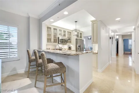 a kitchen with stainless steel appliances granite countertop a stove microwave and refrigerator