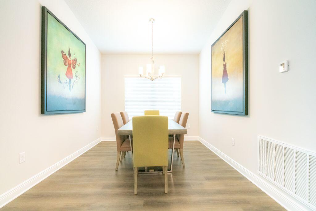 113 Cool Breeze Drive Freeport, FL 32439 - Photo 5 of 16 a view of a dining room with furniture a chandelier and wooden floor