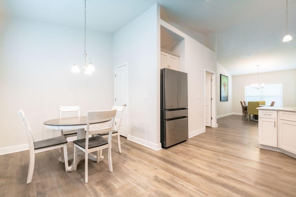 113 Cool Breeze Drive Freeport, FL 32439 - Photo 8 of 16 a kitchen with stainless steel appliances a dining table chairs and wooden floor