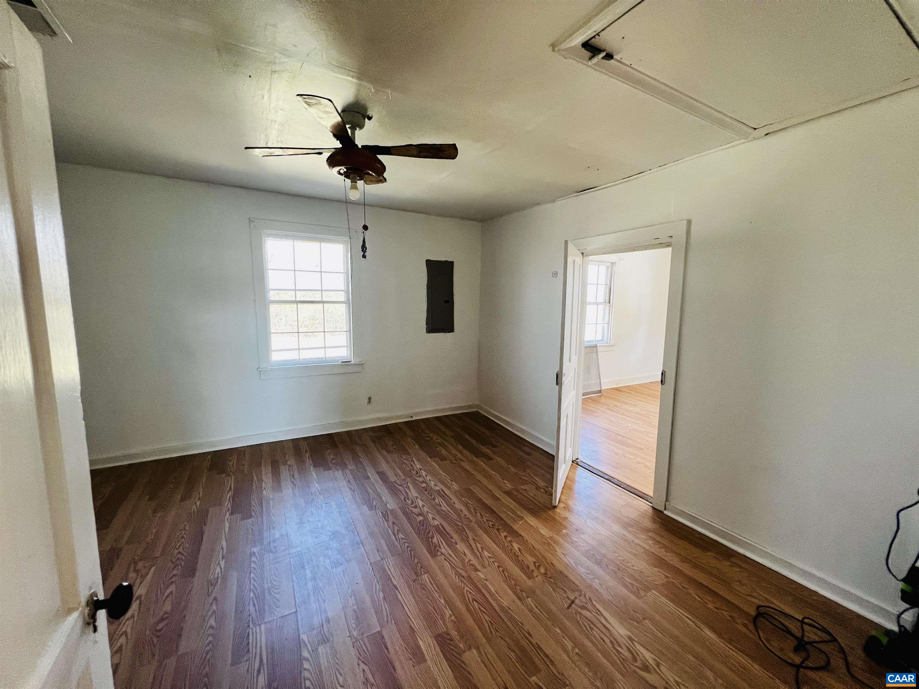 2753 Ridge Road Arvonia, VA 23004 - Photo 6 of 16 an empty room with wooden floor chandelier fan and windows