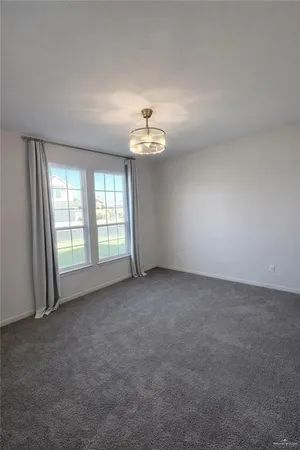an empty room with windows and ceiling fan