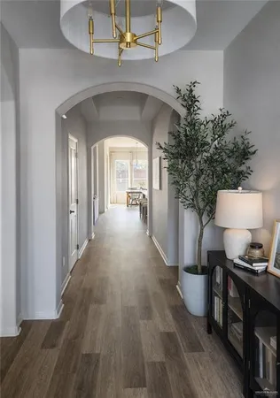 a view of a hallway with wooden floor windows and a kitchen