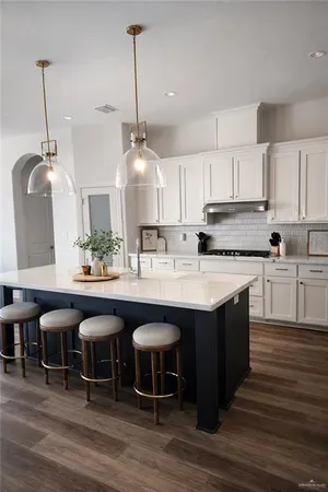 a kitchen with stainless steel appliances granite countertop a kitchen island a stove a table and chairs in it