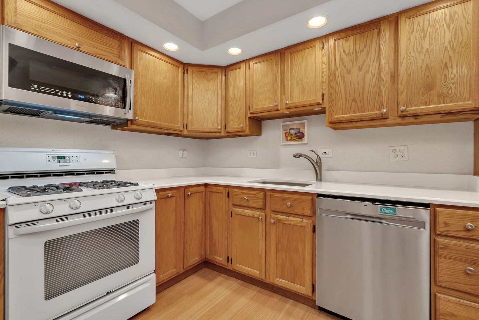 522 Julie Road Bolingbrook, IL 60440 - Photo 10 of 28 a kitchen with stainless steel appliances granite countertop a sink a stove a microwave oven cabinets and wooden floor