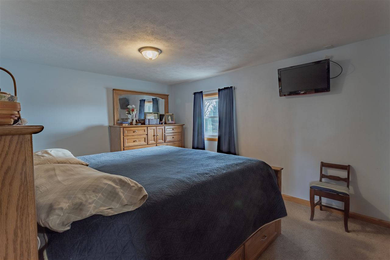 9119 Montague Road Winnebago, IL 61088 - Photo 18 of 36 a bedroom with a bed and a flat screen tv